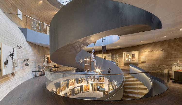 Ausflugstipp PANEUM Große spiralförmige Metallrampe im Museumsraum, umlaufende Ausstellungswand mit Gemälden.