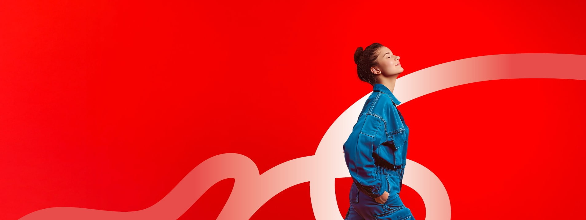A person in a blue jumpsuit walks against a red background with a large white looping ribbon.